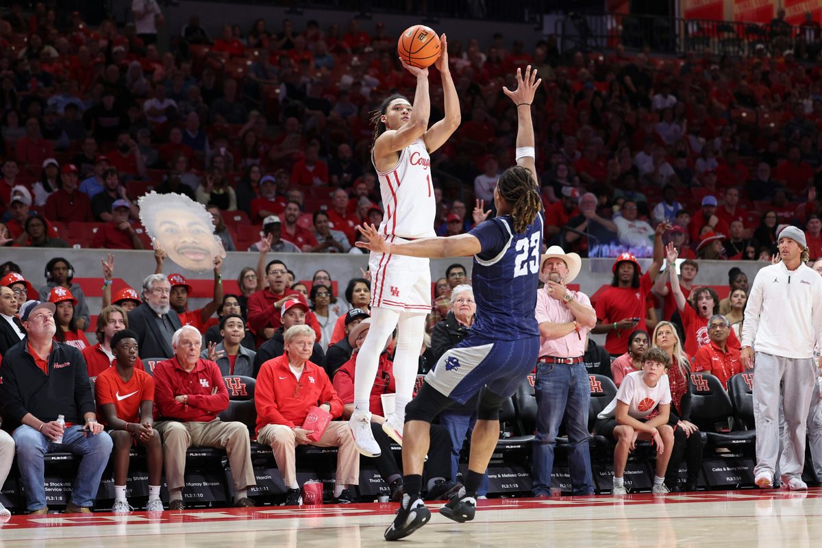 Dec 13, 2025; Houston, Texas, USA; Houston Cougars guard Isiah Harwell (1) shoots the ball as New Orleans Privateers forward MJ Thomas (23) defends during the first half at Fertitta Center. Mandatory Credit: Troy Taormina-Imagn Images