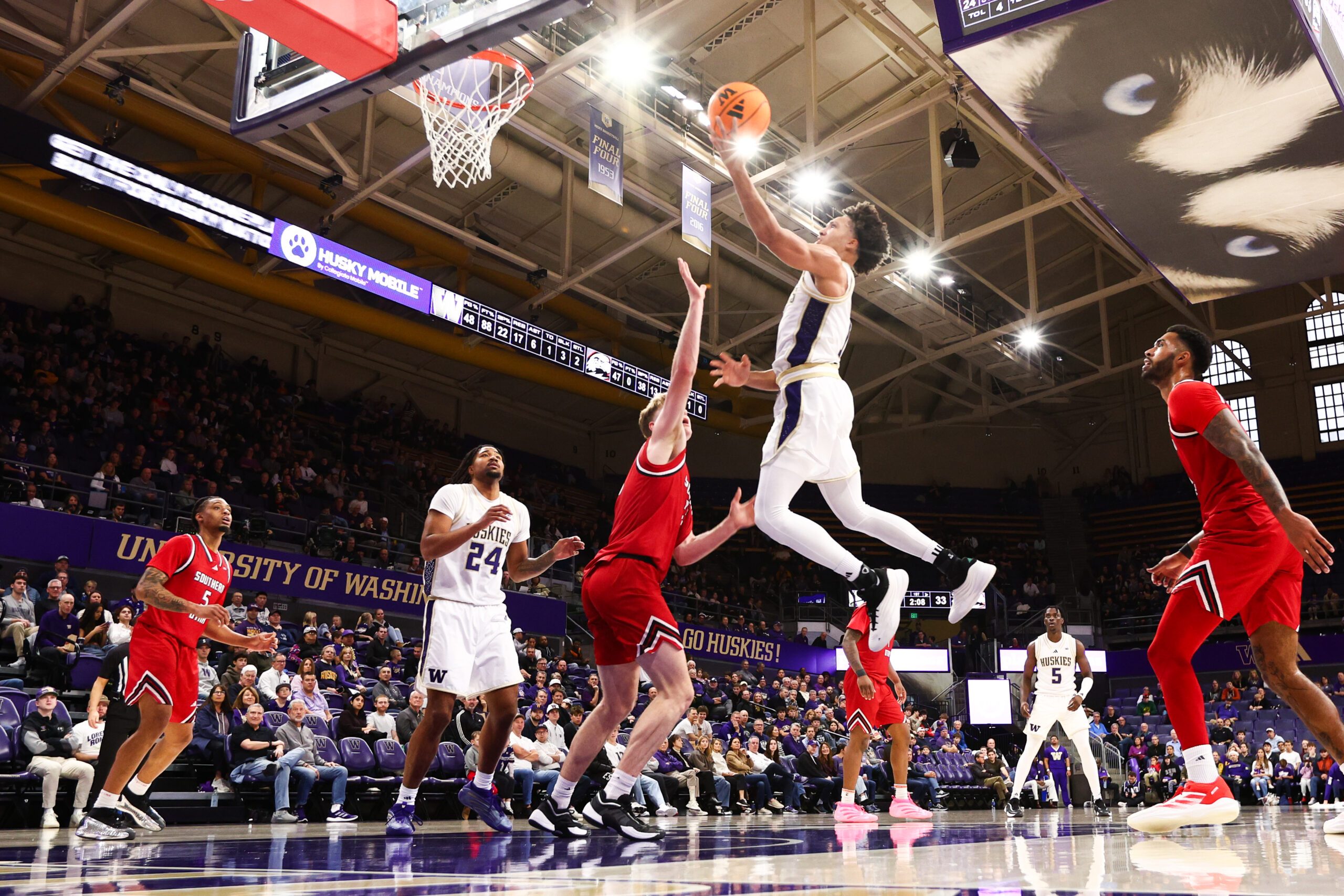 Dec 13, 2025; Seattle, Washington, USA; Washington Huskies guard Desmond Claude (1) shoots a lay up while defended by Southern Utah Thunderbirds forward Jaiden Feroah (35) in the first half at Alaska Airlines Arena at Hec Edmundson Pavilion. Mandatory Credit: Kevin Ng-Imagn Images