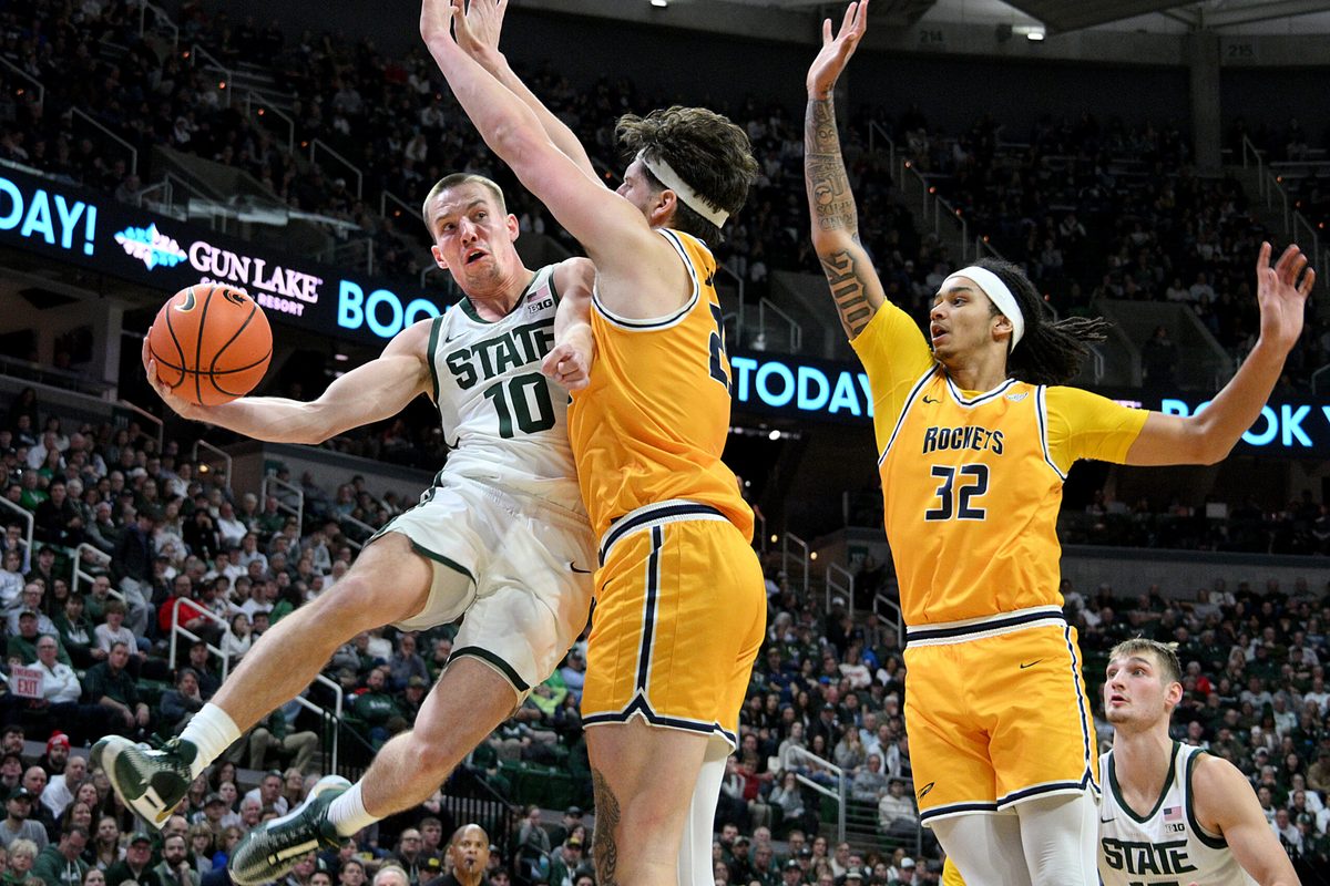 Dec 16, 2025; East Lansing, Michigan, USA; Michigan State Spartans guard Denham Wojcik (10) passes the ball around Toledo Rockets center Austin Parks (25) during the second half at Jack Breslin Student Events Center. Mandatory Credit: Dale Young-Imagn Images