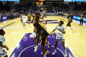 Dec 16, 2025; Evanston, Illinois, USA; Valparaiso Beacons forward JT Pettigrew (7) scores on Northwestern Wildcats forward Nick Martinelli (2) during the second half at Welsh-Ryan Arena. Mandatory Credit: David Banks-Imagn Images