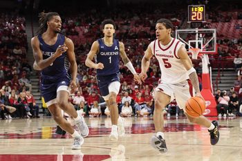 Dec 16, 2025; Fayetteville, Arkansas, USA; Arkansas Razorbacks guard Darius Acuff Jr (5) drives against Queens Royals forward vantage Parker (6) and guard Nasir Mann (1) defend during the second half at Bud Walton Arena. Arkansas won 108-80. Mandatory Credit: Nelson Chenault-Imagn Images