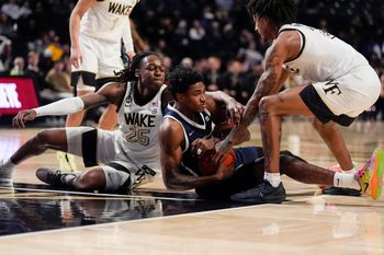 Dec 17, 2025; Winston-Salem, North Carolina, USA; Longwood Lancers forward Elijah Jones (23) tries to hold possession pressured by Wake Forest Demon Deacons forward Tre'Von Spillers (25) and guard Juke Harris (2) during the second half at Lawrence Joel Veterans Memorial Coliseum. Mandatory Credit: Jim Dedmon-Imagn Images