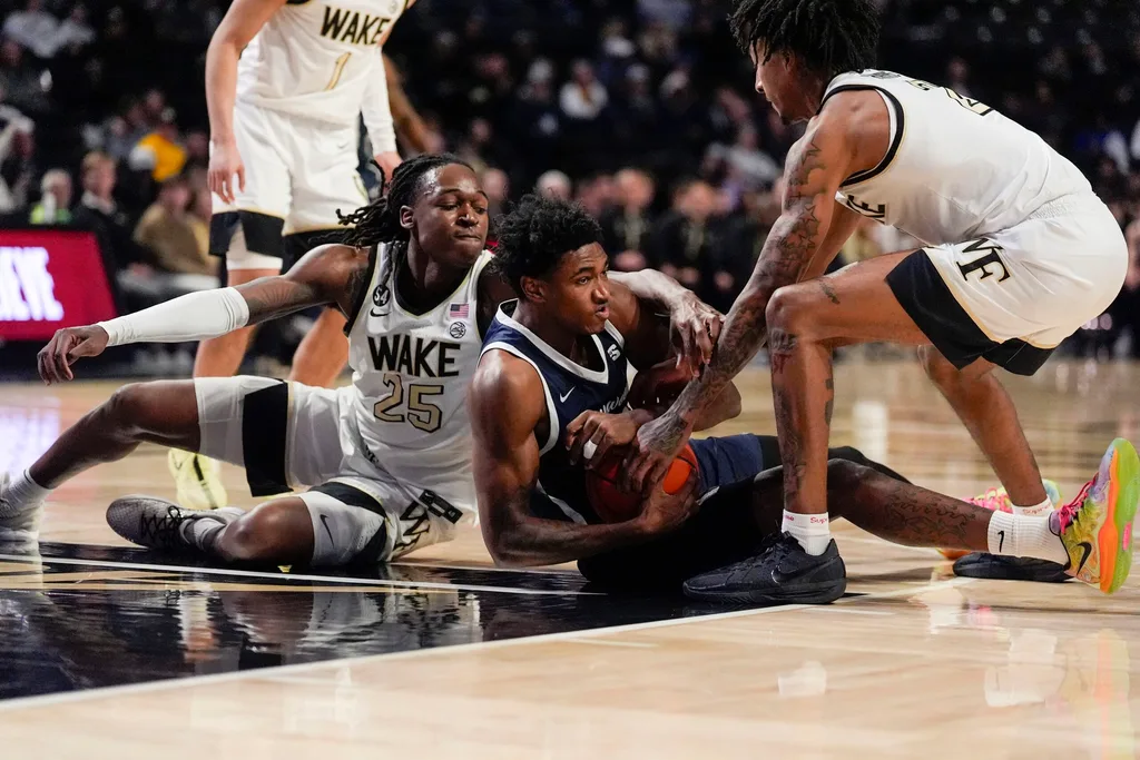 Dec 17, 2025; Winston-Salem, North Carolina, USA; Longwood Lancers forward Elijah Jones (23) tries to hold possession pressured by Wake Forest Demon Deacons forward Tre'Von Spillers (25) and guard Juke Harris (2) during the second half at Lawrence Joel Veterans Memorial Coliseum. Mandatory Credit: Jim Dedmon-Imagn Images