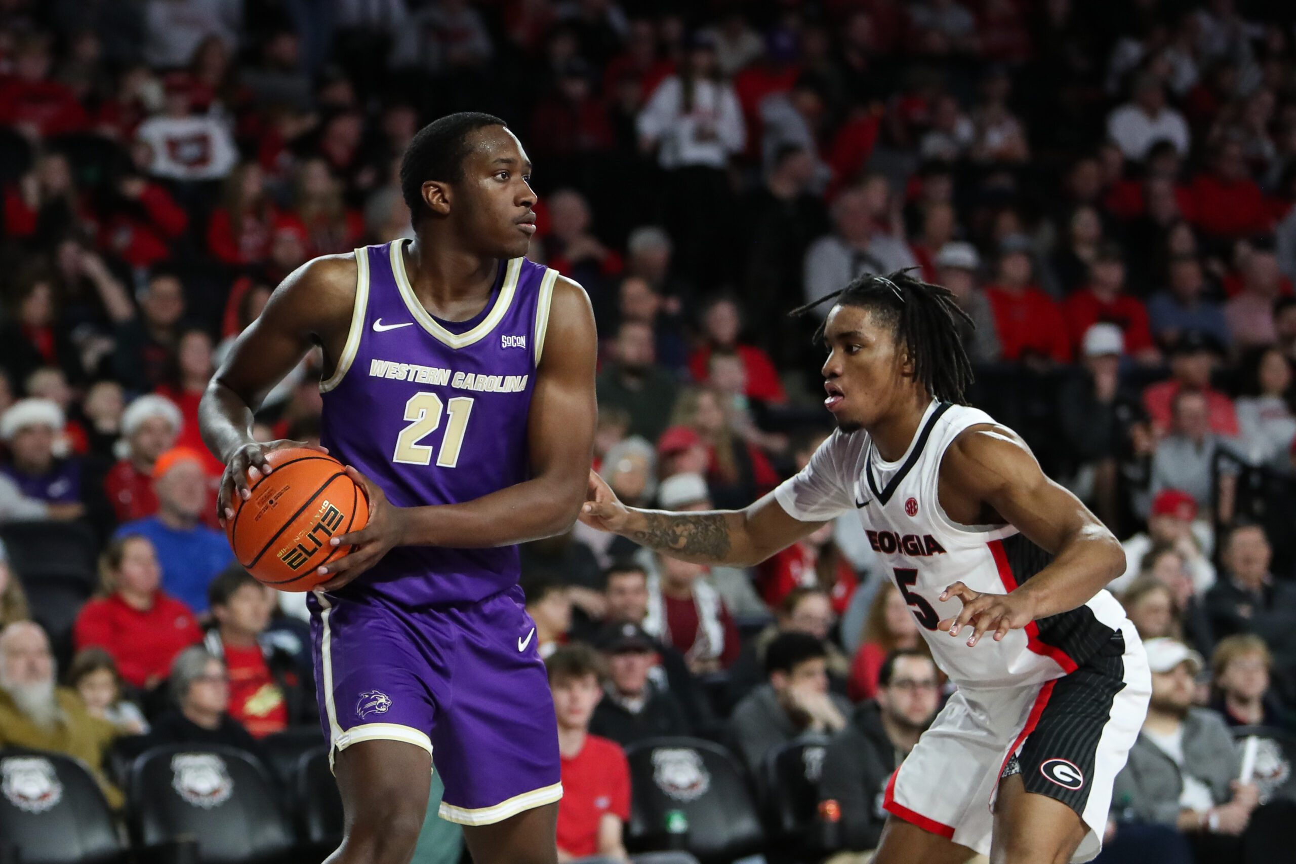 Dec 18, 2025; Athens, Georgia, USA; Western Carolina Catamounts forward Tayeshaun Smith (21) looks to pass against Georgia Bulldogs guard Jeremiah Wilkinson (5) in the second half at Stegeman Coliseum. Mandatory Credit: Mady Mertens-Imagn Images