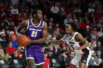 Dec 18, 2025; Athens, Georgia, USA; Western Carolina Catamounts forward Tayeshaun Smith (21) looks to pass against Georgia Bulldogs guard Jeremiah Wilkinson (5) in the second half at Stegeman Coliseum. Mandatory Credit: Mady Mertens-Imagn Images