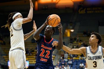 Dec 19, 2025; Berkeley, California, USA; Morgan State Bears forward Manok Lual (22) drives to the basket against California Golden Bears forward Chris Bell (22) and guard Semetri Carr (3) during the second half at Haas Pavilion. Mandatory Credit: Robert Edwards-Imagn Images