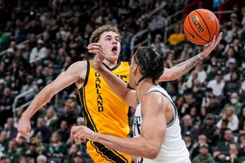 Oakland guard Brody Robinson (55) makes a layup against Michigan State forward Jesse McCulloch (35) during the first half at Little Caesars Arena in Detroit on Saturday, Dec. 20, 2025.