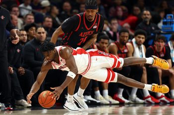 Dec 20, 2025; Phoenix, Arizona, USA; Arizona Wildcats forward Dwayne Aristode (2) dives for a loose ball against San Diego State Aztecs guard Taj DeGourville (24) in the second half during the Hall of Fame Series at Mortgage Matchup Center. Mandatory Credit: Mark J. Rebilas-Imagn Images
