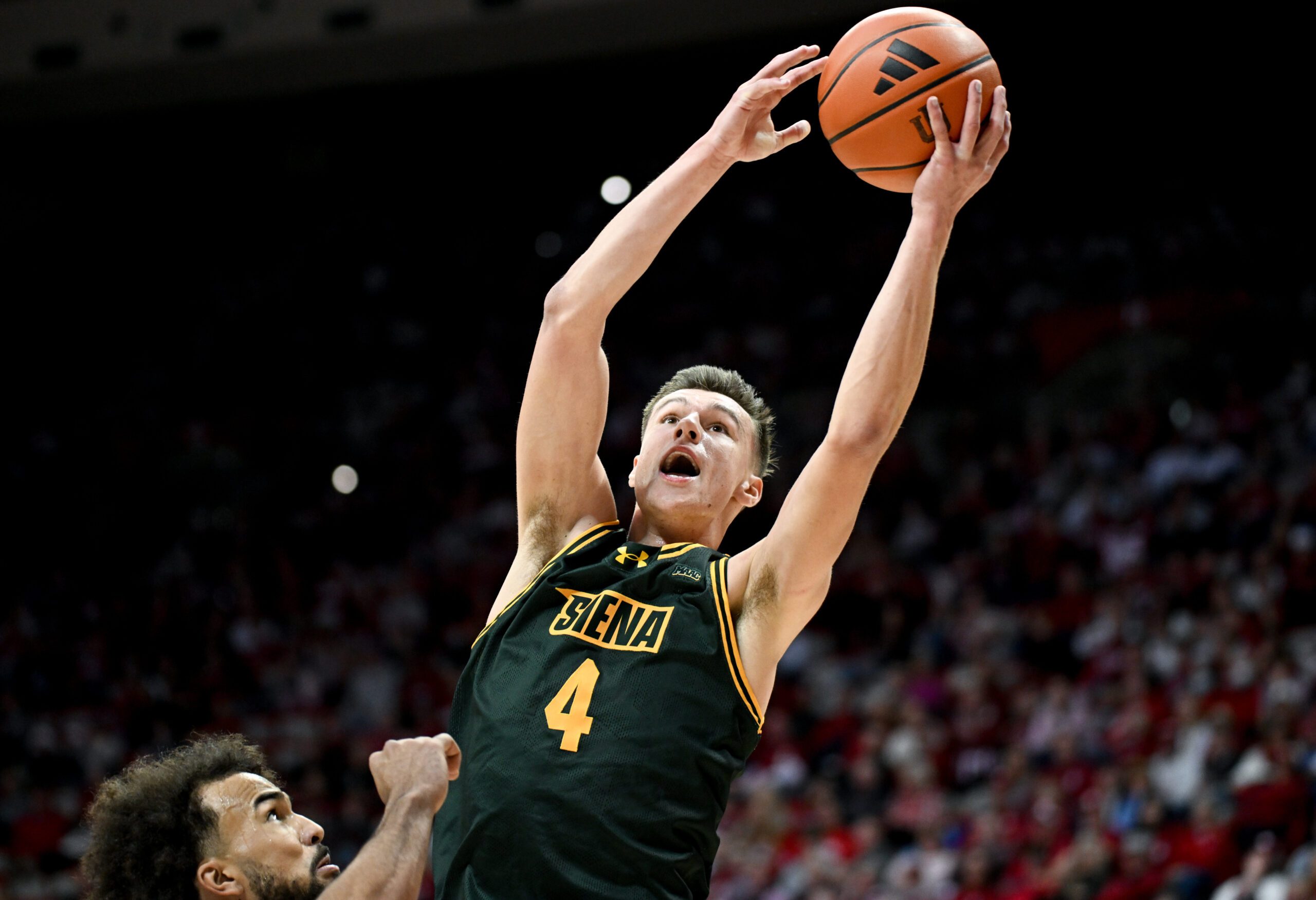 Dec 22, 2025; Bloomington, Indiana, USA; Siena Saints guard Gavin Doty (4) scores past Indiana Hoosiers guard Tayton Conerway (6) during the second half at Simon Skjodt Assembly Hall. Mandatory Credit: Robert Goddin-Imagn Images