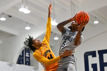 Dec 22, 2025; Washington, District of Columbia, USA; Georgetown Hoyas guard Kj Lewis (5) is fouled by Coppin State Eagles guard Jamari Piercy (14) during the first half at McDonough Arena. Mandatory Credit: Brad Mills-Imagn Images