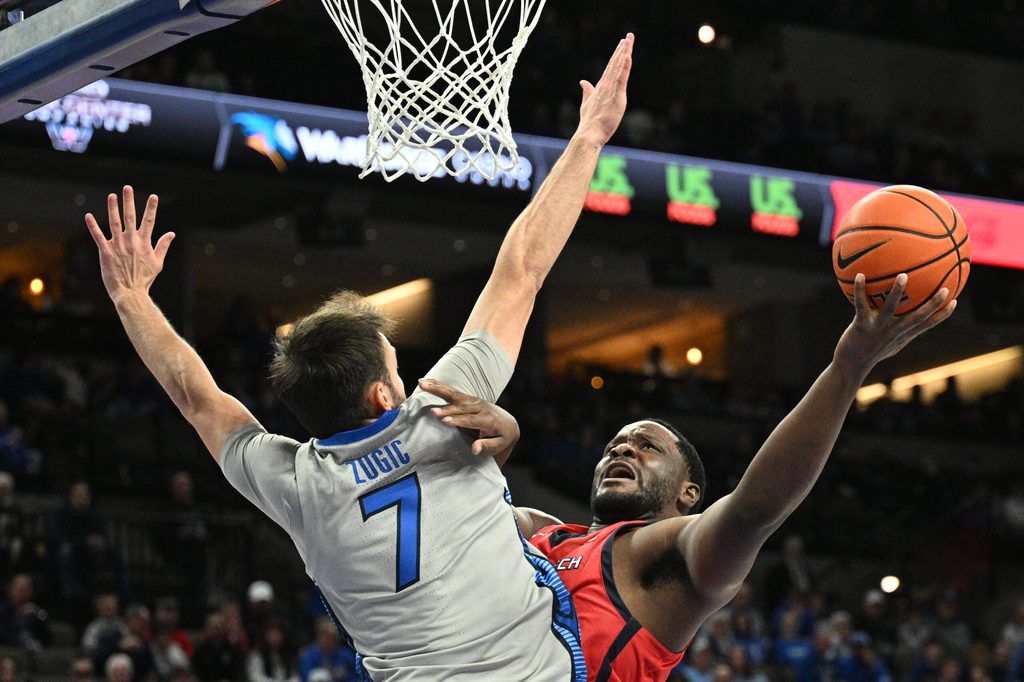 Dec 22, 2025; Omaha, Nebraska, USA; Utah Tech Trailblazers forward Dario Domingos (52) attempts a shot over Creighton Bluejays guard Fedor Zugic (7) during the first half at CHI Health Center Omaha. Mandatory Credit: Steven Branscombe-Imagn Images