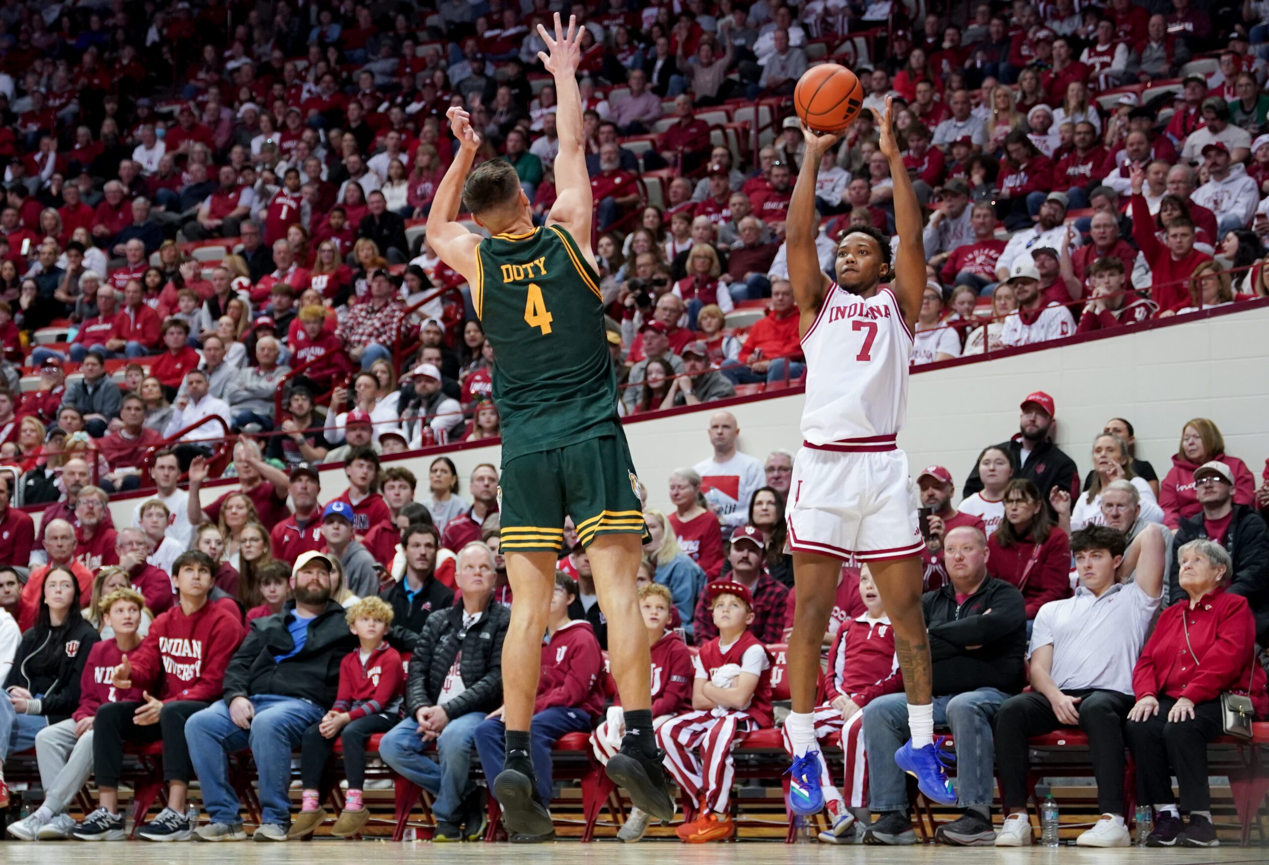Dec 22, 2025; Bloomington, Indiana, USA; Indiana Hoosiers forward Nick Dorn (7) makes a three-point basket over Siena Saints guard Gavin Doty (4) during the first half at Simon Skjodt Assembly Hall. Mandatory Credit: Robert Goddin-Imagn Images