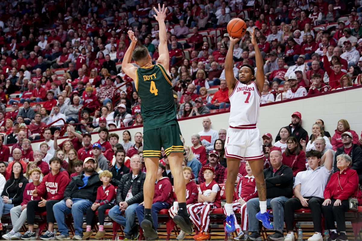 Dec 22, 2025; Bloomington, Indiana, USA; Indiana Hoosiers forward Nick Dorn (7) makes a three-point basket over Siena Saints guard Gavin Doty (4) during the first half at Simon Skjodt Assembly Hall. Mandatory Credit: Robert Goddin-Imagn Images