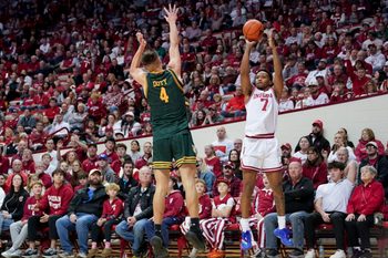 Dec 22, 2025; Bloomington, Indiana, USA; Indiana Hoosiers forward Nick Dorn (7) makes a three-point basket over Siena Saints guard Gavin Doty (4) during the first half at Simon Skjodt Assembly Hall. Mandatory Credit: Robert Goddin-Imagn Images