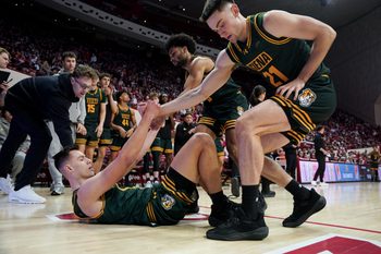 Dec 22, 2025; Bloomington, Indiana, USA; Siena Saints forward Brendan Coyle (21) and Siena Saints guard Justice Shoats (0) help up Siena Saints guard Gavin Doty (4) during the second half against the Indiana Hoosiers at Simon Skjodt Assembly Hall. Mandatory Credit: Robert Goddin-Imagn Images