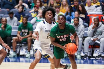 Dec 22, 2025; Morgantown, West Virginia, USA; Mississippi Valley State Delta Devils guard Michael James (10) drives baseline past West Virginia Mountaineers guard Amir Jenkins (2) during the second half at Hope Coliseum. Mandatory Credit: Ben Queen-Imagn Images