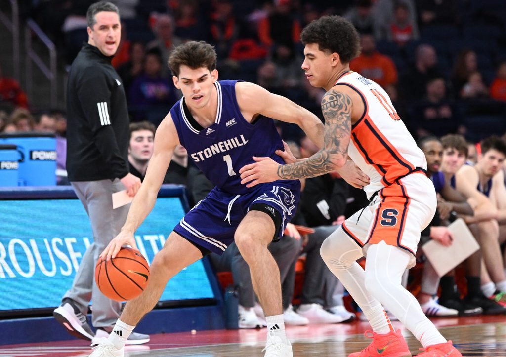 Dec 22, 2025; Syracuse, New York, USA; Stonehill Skyhawks guard Rex Sunderland (1) tries to move past Syracuse Orange guard Naithan George (11) in the second half at the JMA Wireless Dome. Mandatory Credit: Mark Konezny-Imagn Images