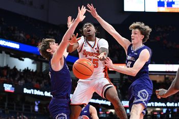 Dec 22, 2025; Syracuse, New York, USA; Syracuse Orange Guard Bryce Zephir (55) is fouled on a play with Stonehill Skyhawks forward Cory Lovell (left) and forward Pearse McGuinn (31) in the second half at the JMA Wireless Dome. Mandatory Credit: Mark Konezny-Imagn Images