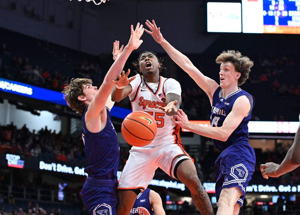 Dec 22, 2025; Syracuse, New York, USA; Syracuse Orange Guard Bryce Zephir (55) is fouled on a play with Stonehill Skyhawks forward Cory Lovell (left) and forward Pearse McGuinn (31) in the second half at the JMA Wireless Dome. Mandatory Credit: Mark Konezny-Imagn Images