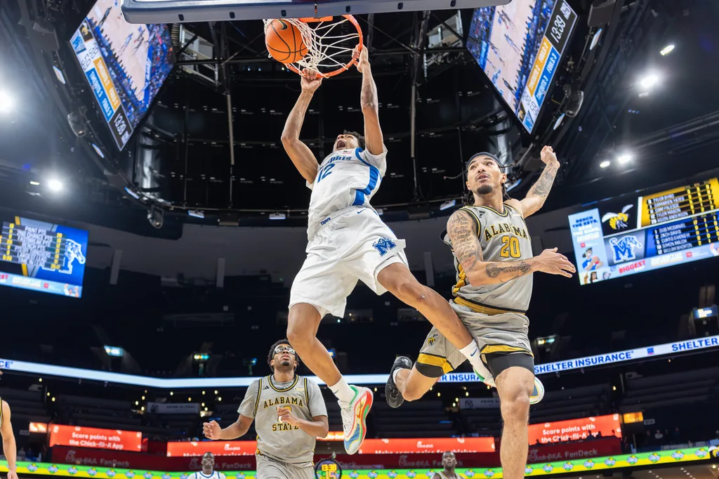 Dec 22, 2025; Memphis, Tennessee, USA; Memphis Tigers forward William Whorton (12) dunks the ball against Alabama State Hornets guard Asjon Anderson (20) during the second half at FedExForum. Mandatory Credit: Wesley Hale-Imagn Images