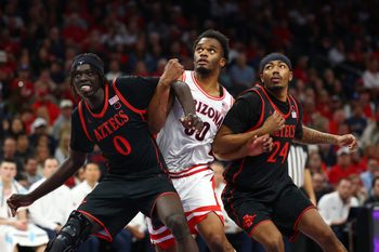 Dec 20, 2025; Phoenix, Arizona, USA; Arizona Wildcats forward Tobe Awaka (30) against San Diego State Aztecs forward Magoon Gwath (0) and guard Taj DeGourville (24) during the Hall of Fame Series at Mortgage Matchup Center. Mandatory Credit: Mark J. Rebilas-Imagn Images