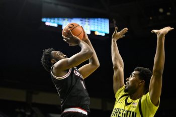 Dec 28, 2025; Eugene, Oregon, USA; Omaha Mavericks guard Paul Djobet (11) shoots the ball over Oregon Ducks forward Sean Stewart (13) during the second half at Matthew Knight Arena. Mandatory Credit: Craig Strobeck-Imagn Images