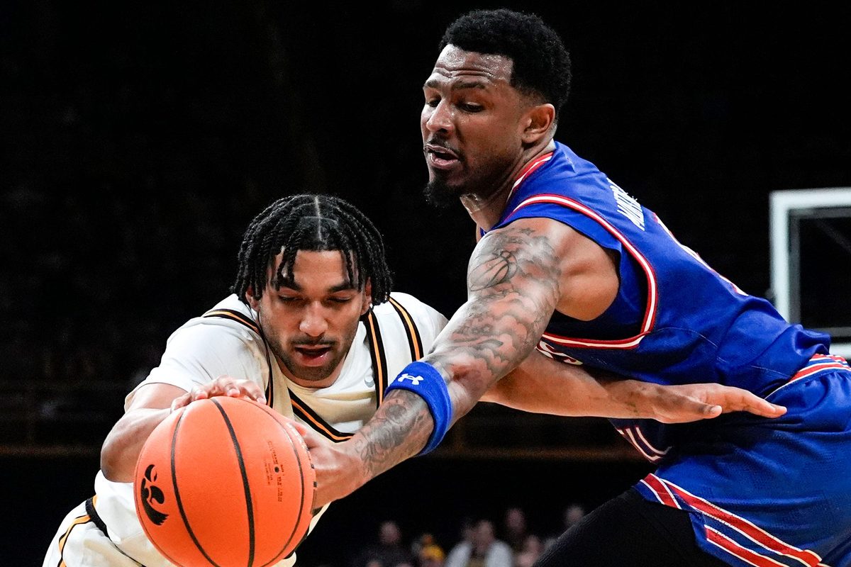 Iowa guard Kael Combs (11) and UMass Lowell guard Angel Montas Jr. (9) reach for the ball Dec. 29, 2025 at Carver-Hawkeye Arena in Iowa City, Iowa.