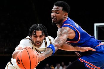 Iowa guard Kael Combs (11) and UMass Lowell guard Angel Montas Jr. (9) reach for the ball Dec. 29, 2025 at Carver-Hawkeye Arena in Iowa City, Iowa.