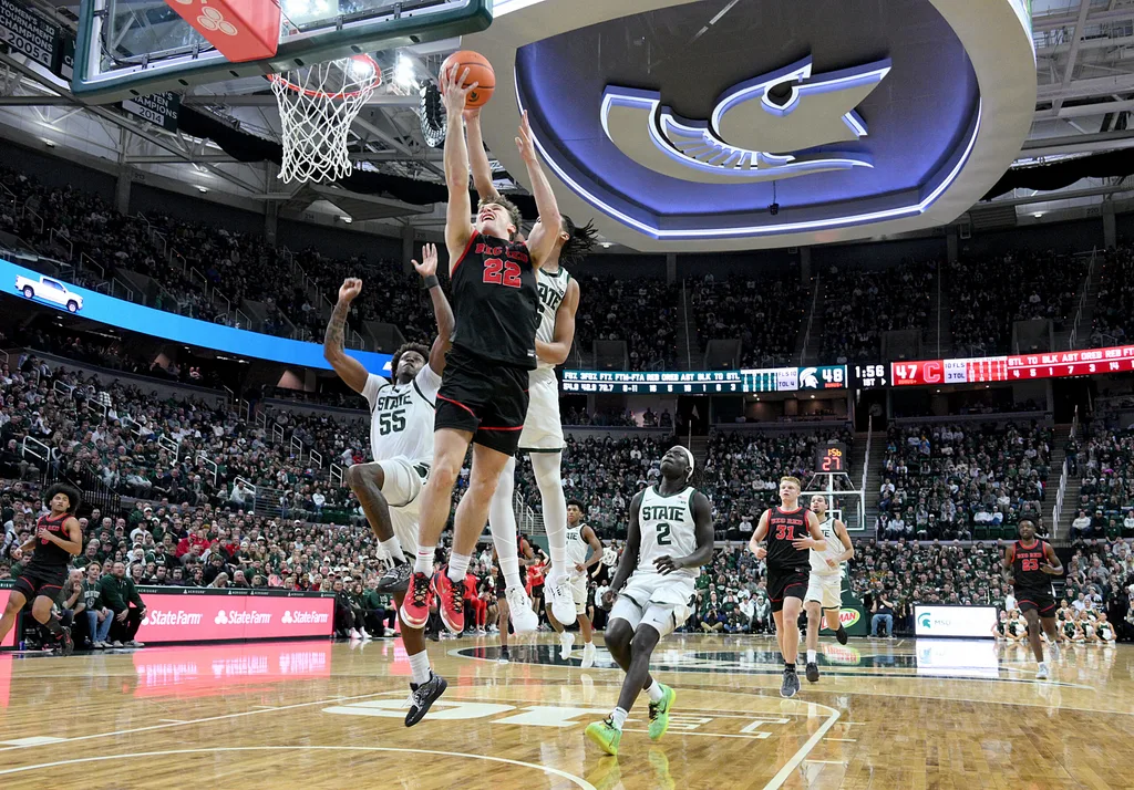 Dec 29, 2025; East Lansing, Michigan, USA; Cornell Big Red guard Jake Fiegen (22) gets his layup blocked by Michigan State Spartans forward Jordan Scott (6) during the first half at Jack Breslin Student Events Center. Mandatory Credit: Dale Young-Imagn Images