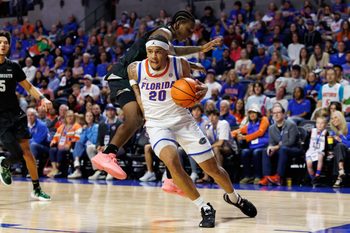 Dec 29, 2025; Gainesville, Florida, USA; Florida Gators guard Isaiah Brown (20) drives to the basket past Dartmouth Big Green guard Kareem Thomas (2) during the second half at Exactech Arena at the Stephen C. O'Connell Center. Mandatory Credit: Matt Pendleton-Imagn Images