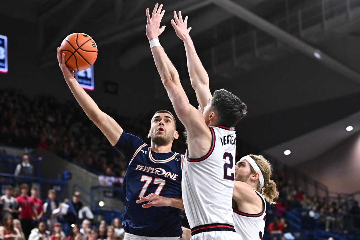 Jan 21, 2026; Spokane, Washington, USA; Pepperdine Waves guard Luka Vudragovic (77) shoots the ball against Gonzaga Bulldogs forward Steele Venters (2) in the second half at McCarthey Athletic Center. Mandatory Credit: James Snook-Imagn Images