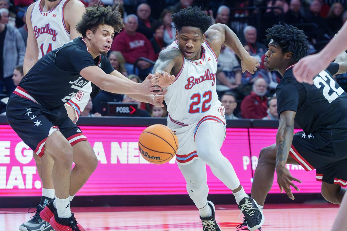 UIC's Elijah Crawford, left, and Mekhi Lowery, right, try to steal the ball from Bradley's Jaquan Johnson in the first half of their college basketball game Saturday, Jan. 24, 2026 at Carver Arena. The Braves fell to the Flames 85-70.