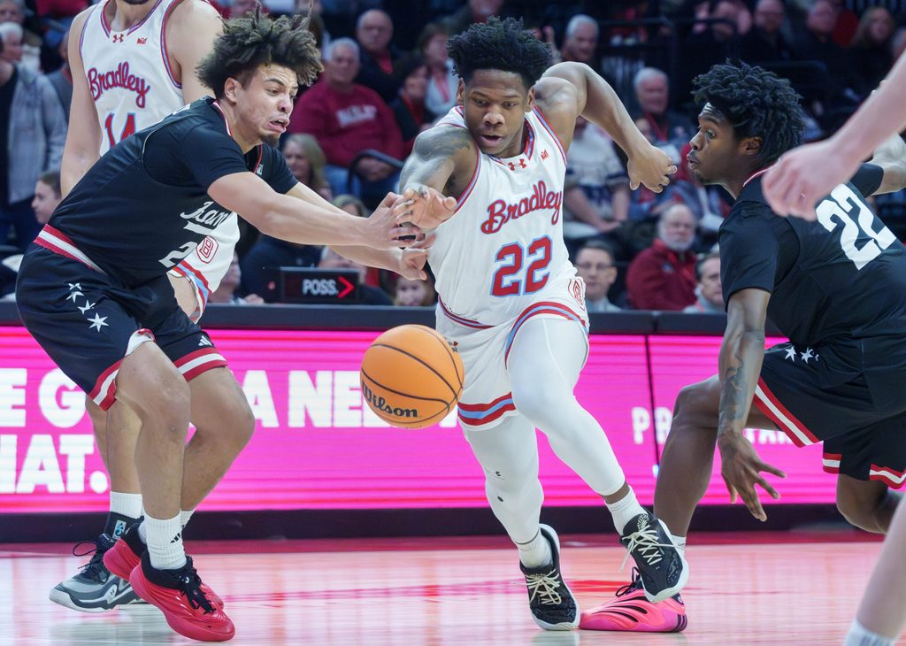 UIC's Elijah Crawford, left, and Mekhi Lowery, right, try to steal the ball from Bradley's Jaquan Johnson in the first half of their college basketball game Saturday, Jan. 24, 2026 at Carver Arena. The Braves fell to the Flames 85-70.