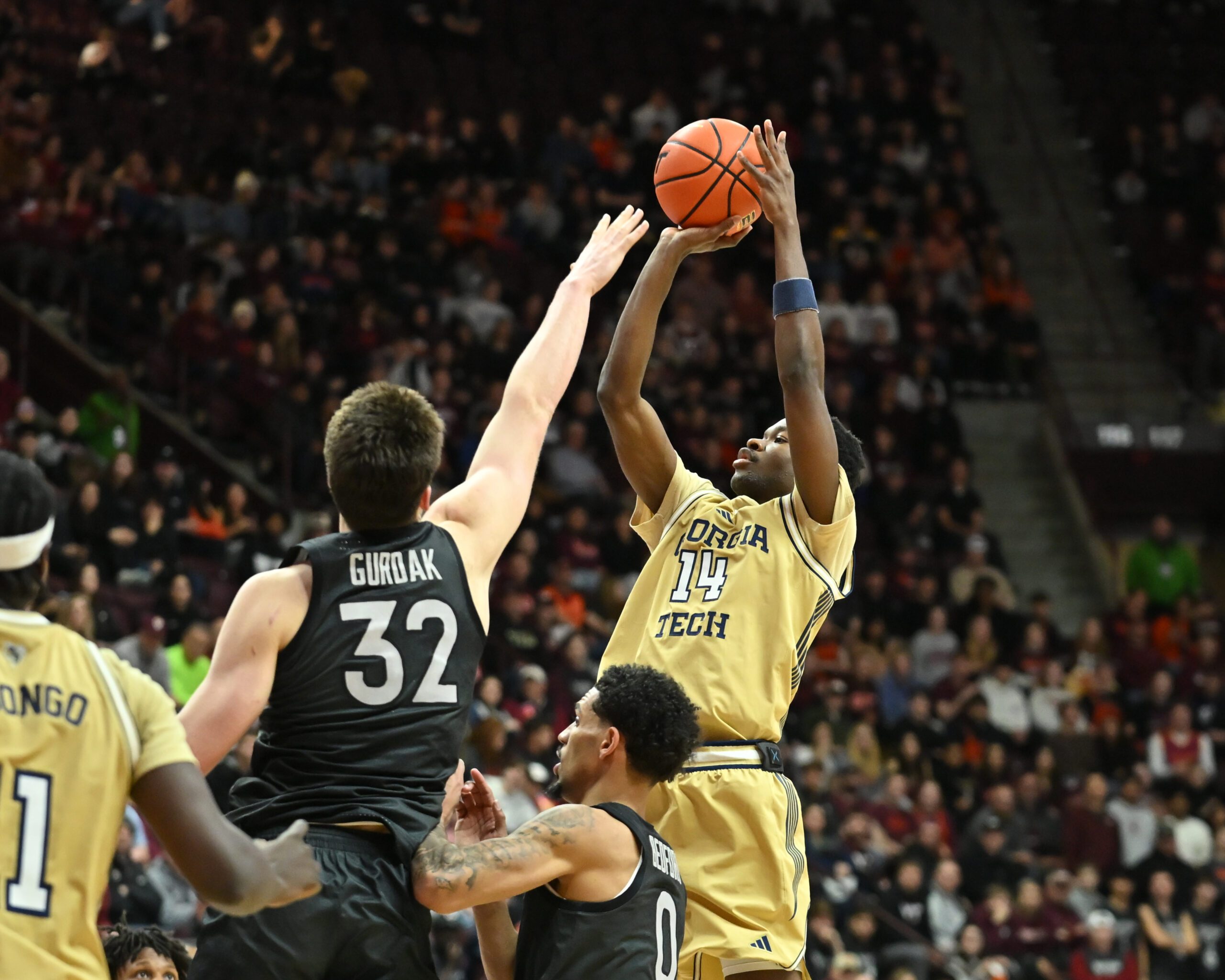 Jan 27, 2026; Blacksburg, Virginia, USA;  Georgia Tech Yellow Jackets forward Kowacie Reeves Jr. (14) shoots a shot as Virginia Tech Hokies center Christian Gurdak (32) defends during the first half at Cassell Coliseum. Mandatory Credit: Brian Bishop-Imagn Images