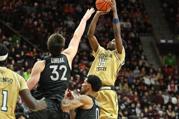 Jan 27, 2026; Blacksburg, Virginia, USA;  Georgia Tech Yellow Jackets forward Kowacie Reeves Jr. (14) shoots a shot as Virginia Tech Hokies center Christian Gurdak (32) defends during the first half at Cassell Coliseum. Mandatory Credit: Brian Bishop-Imagn Images