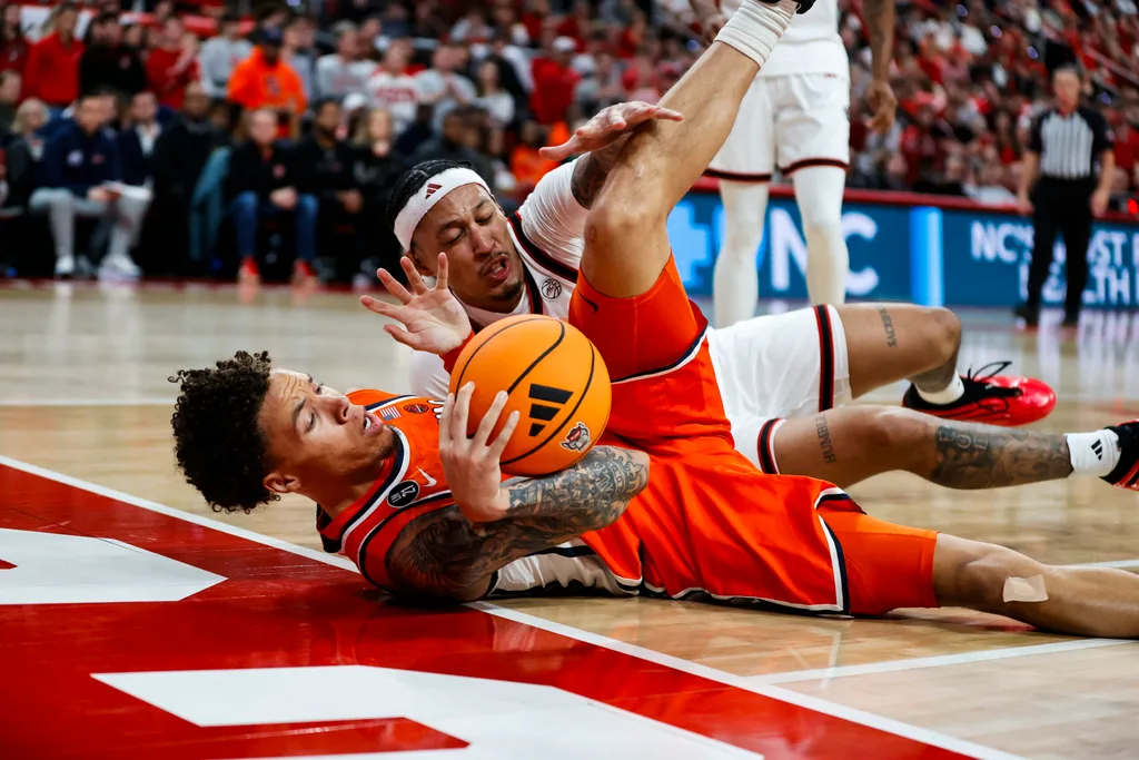 Jan 27, 2026; Raleigh, North Carolina, USA; NC State Wolfpack forward Darrion Williams (1) and Syracuse Orange guard Nate Kingz (4) react to the call during the second half of the game at Lenovo Center. Mandatory Credit: Jaylynn Nash-Imagn Images