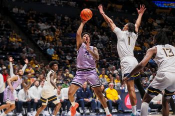 Jan 27, 2026; Morgantown, West Virginia, USA; Kansas State Wildcats guard PJ Haggerty (4) shoots in the lane against West Virginia Mountaineers guard Jasper Floyd (1) during the first half at Hope Coliseum. Mandatory Credit: Ben Queen-Imagn Imagesa