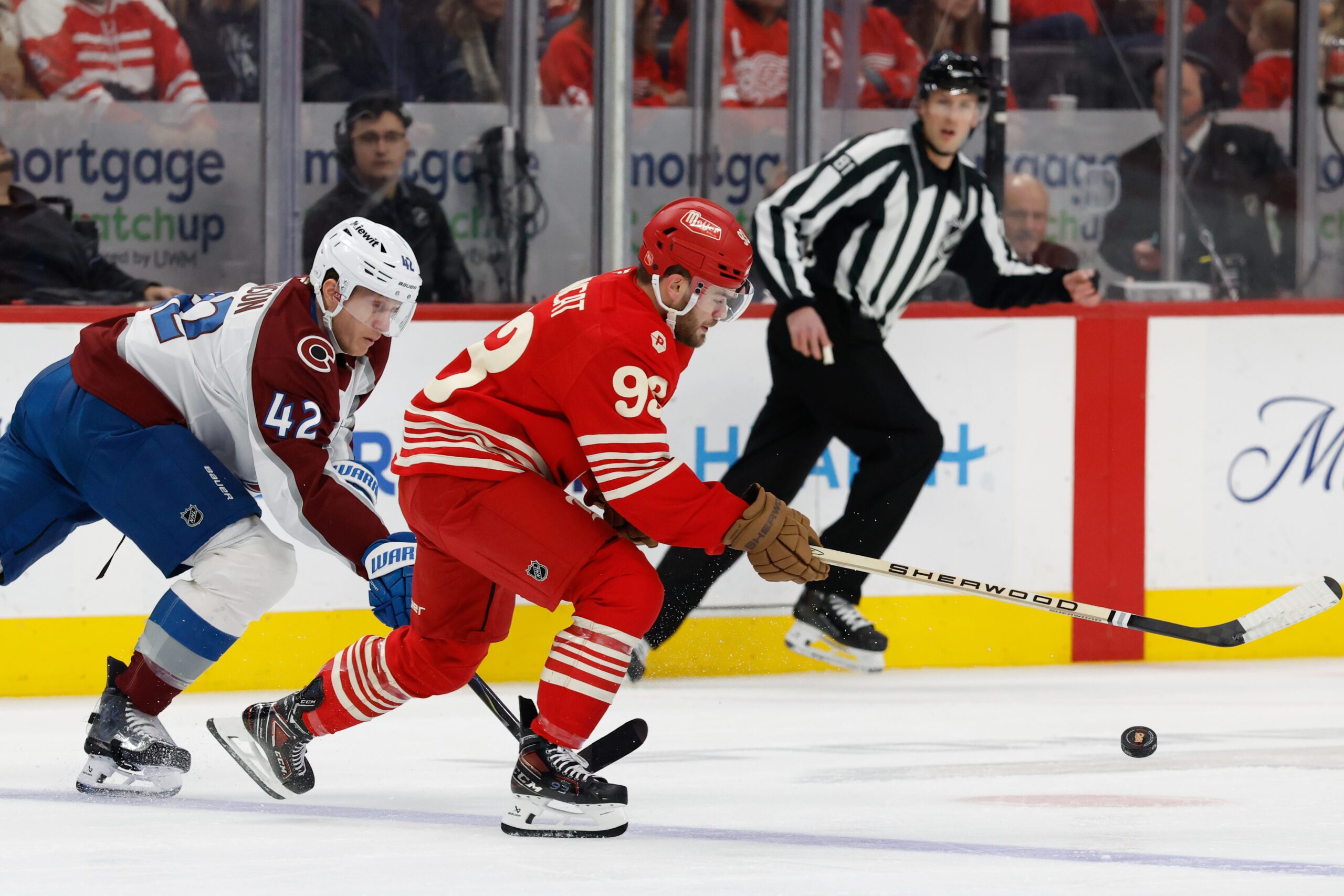 Jan 31, 2026; Detroit, Michigan, USA;  Detroit Red Wings right wing Alex DeBrincat (93) skates with the puck against Colorado Avalanche defenseman Josh Manson (42) in the first period at Little Caesars Arena. Mandatory Credit: Rick Osentoski-Imagn Images