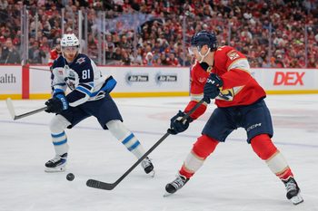 Jan 31, 2026; Sunrise, Florida, USA; Florida Panthers center Sam Reinhart (13) moves the puck against Winnipeg Jets left wing Kyle Connor (81) during the second period at Amerant Bank Arena. Mandatory Credit: Sam Navarro-Imagn Images