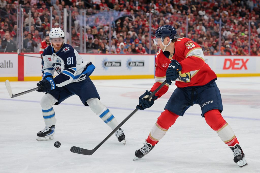 Jan 31, 2026; Sunrise, Florida, USA; Florida Panthers center Sam Reinhart (13) moves the puck against Winnipeg Jets left wing Kyle Connor (81) during the second period at Amerant Bank Arena. Mandatory Credit: Sam Navarro-Imagn Images