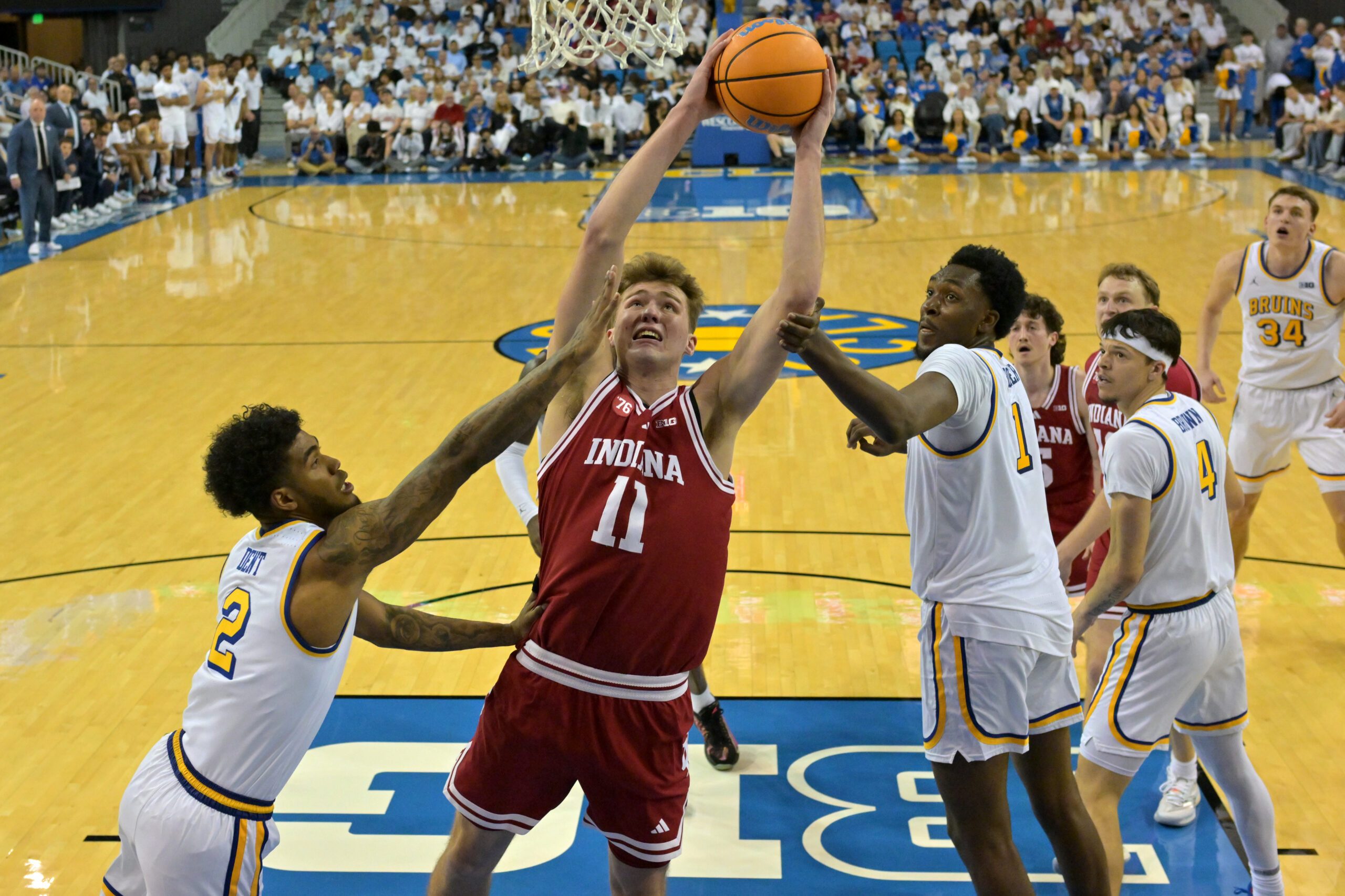 Jan 31, 2026; Los Angeles, California, USA;  Indiana Hoosiers forward Trent Sisley (11) is defended by UCLA Bruins guard Donovan Dent (2) and forward Xavier Booker (1) in the second half at Pauley Pavilion presented by Wescom Financial. Mandatory Credit: Jayne Kamin-Oncea-Imagn Images