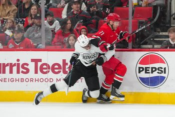 Feb 1, 2026; Raleigh, North Carolina, USA; Los Angeles Kings right wing Quinton Byfield (55) checks Carolina Hurricanes left wing Taylor Hall (71) during the first period at Lenovo Center. Mandatory Credit: James Guillory-Imagn Images