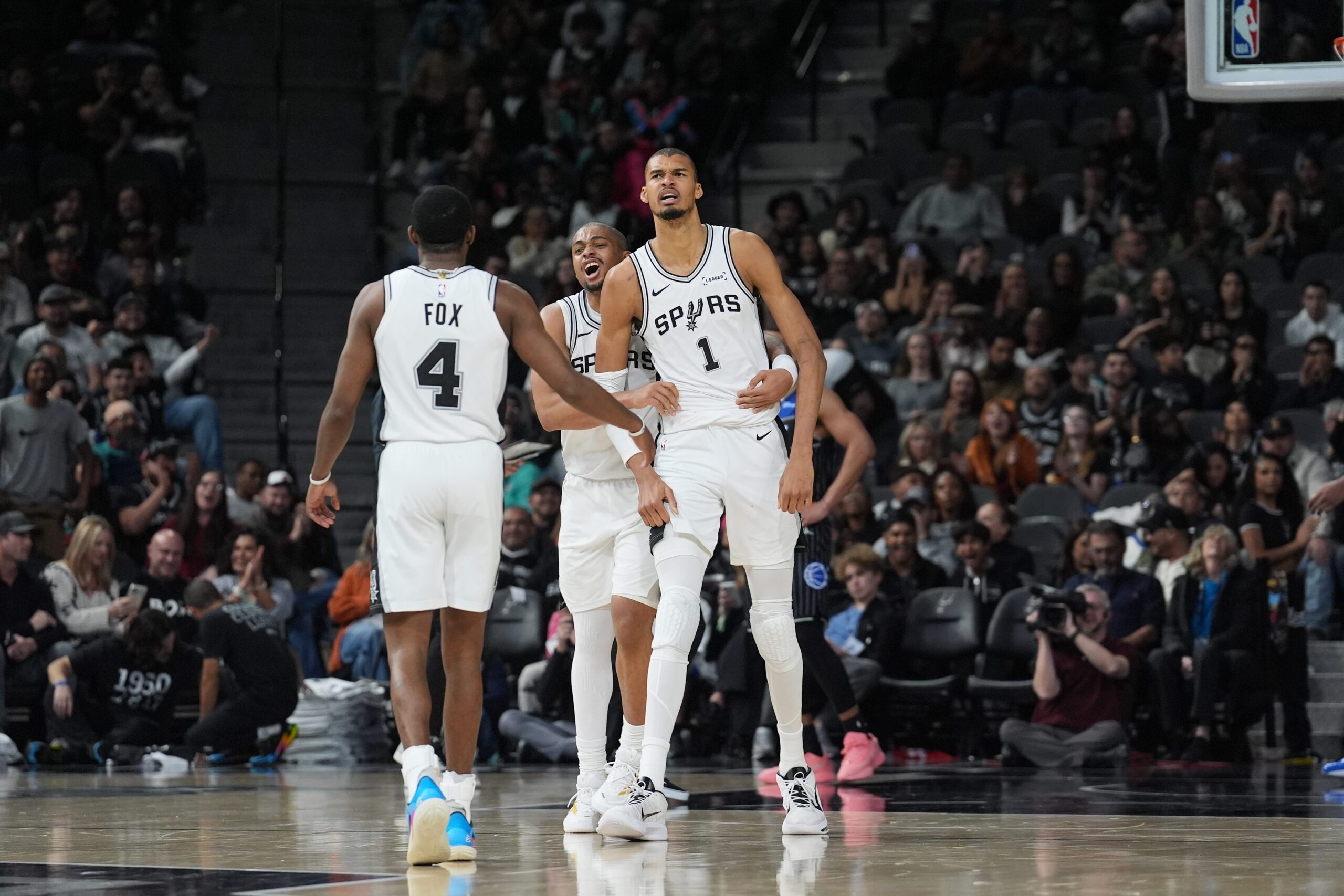 Feb 1, 2026; San Antonio, Texas, USA;  San Antonio Spurs forward Keldon Johnson (3) and guard De'aaron Fox (4) celebrate with forward Victor Wembanyama (1) in the second half against the Orlando Magic at Frost Bank Center. Mandatory Credit: Daniel Dunn-Imagn Images
