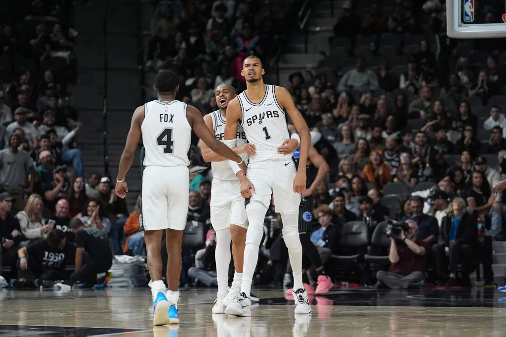 Feb 1, 2026; San Antonio, Texas, USA; San Antonio Spurs forward Keldon Johnson (3) and guard De'aaron Fox (4) celebrate with forward Victor Wembanyama (1) in the second half against the Orlando Magic at Frost Bank Center. Mandatory Credit: Daniel Dunn-Imagn Images