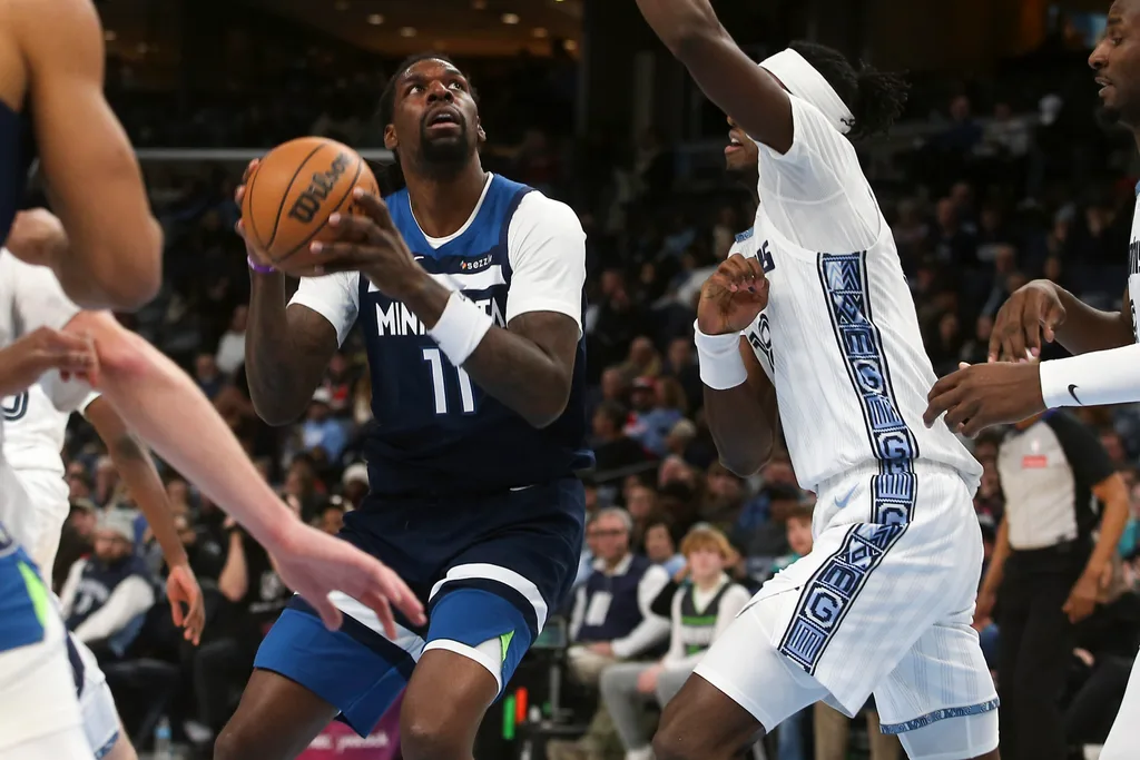 Feb 2, 2026; Memphis, Tennessee, USA; Minnesota Timberwolves center Naz Reid (11) drives to the basket as Memphis Grizzlies forward Olivier-Maxence Prosper (18) defends during the fourth quarter at FedExForum. Mandatory Credit: Petre Thomas-Imagn Images