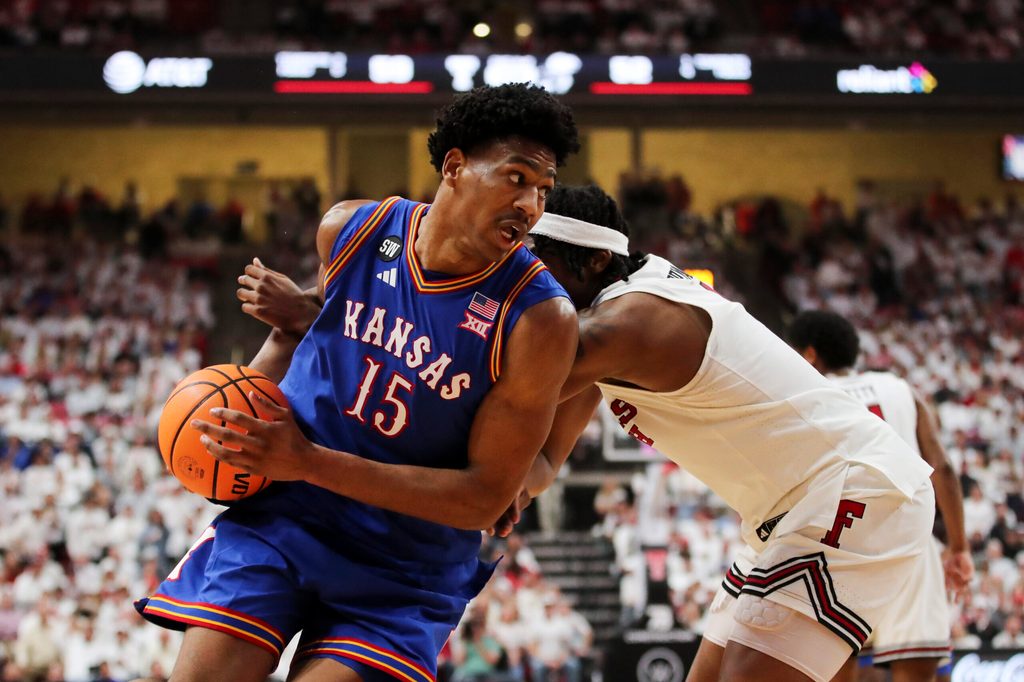 Feb 2, 2026; Lubbock, Texas, USA; Kansas Jayhawks guard Bryson Tiller (15) drives the ball around Texas Tech Red Raiders guard Tyeree Byran (1) in the second half at United Supermarkets Arena. Mandatory Credit: Michael C. Johnson-Imagn Images