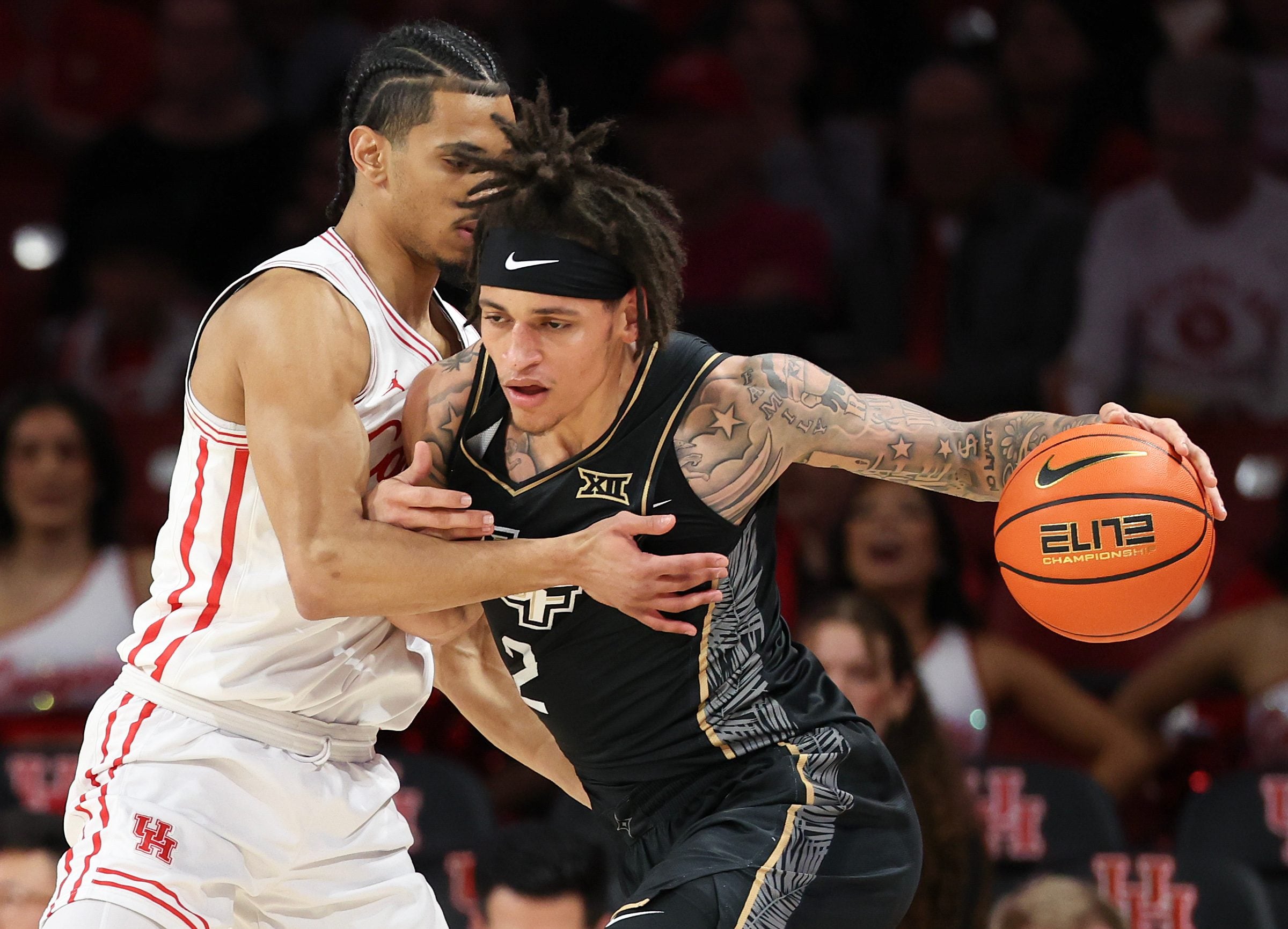 Feb 4, 2026; Houston, Texas, USA;  UCF Knights guard Riley Kugel (2) drives against Houston Cougars guard Milos Uzan (7) in the first half at Fertitta Center. Mandatory Credit: Thomas Shea-Imagn Images