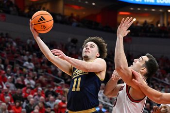 Feb 4, 2026; Louisville, Kentucky, USA;  Notre Dame Fighting Irish guard Braeden Shrewsberry (11) shoots against Louisville Cardinals forward Vangelis Zougris (53) during the first half at KFC Yum! Center. Mandatory Credit: Jamie Rhodes-Imagn Images