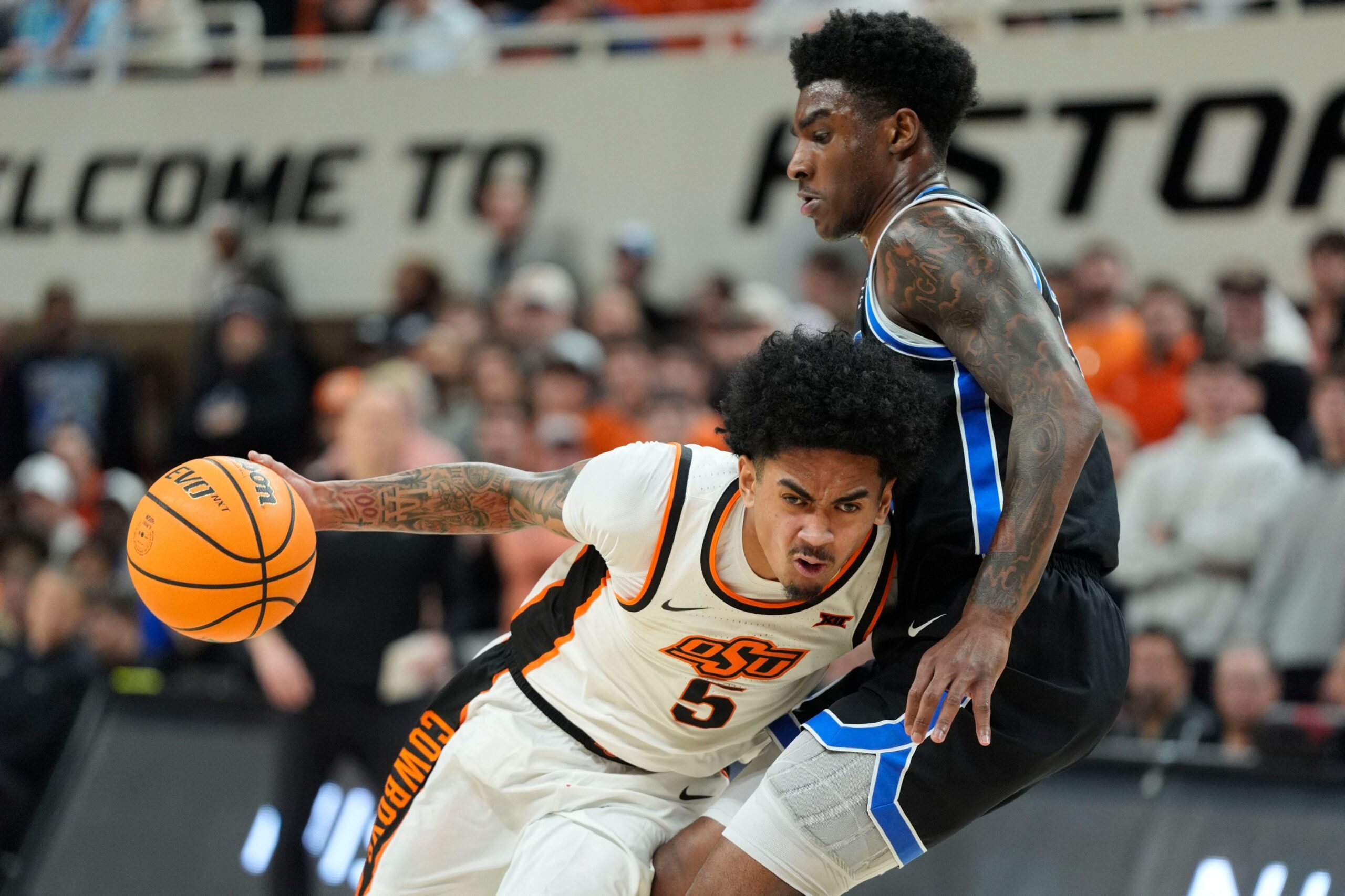 Oklahoma State Cowboys guard Vyctorius Miller (5) dribbles beside BYU Cougars forward Kennard Davis Jr. (30) during a BIG 12 men's college basketball game between the Oklahoma State Cowboys (OSU) and the BYU Cougars at Gallagher-Iba Arena in Stillwater, Okla., Wednesday, Feb. 4, 2026.