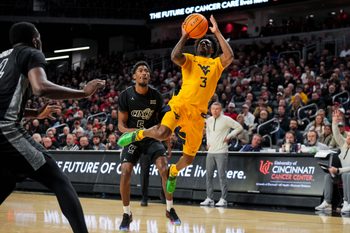 Feb 5, 2026; Cincinnati, Ohio, USA;  West Virginia Mountaineers guard Honor Huff (3) drives to the basket against Cincinnati Bearcats guard Sencire Harris (5) in the second half at Fifth Third Arena. Mandatory Credit: Aaron Doster-Imagn Images